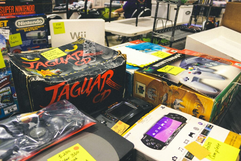 Consoles de videogame vintage e eletrônicos retrô expostos sobre uma mesa