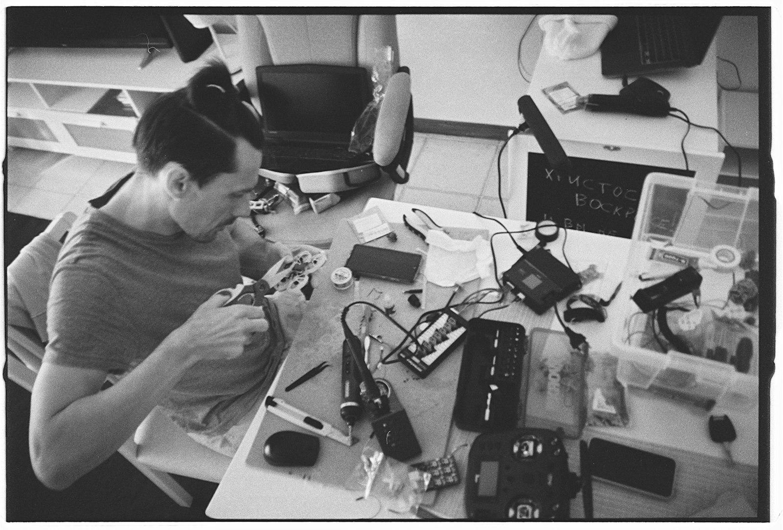 Pessoa fazendo manutenção em eletrônicos sobre uma mesa de trabalho