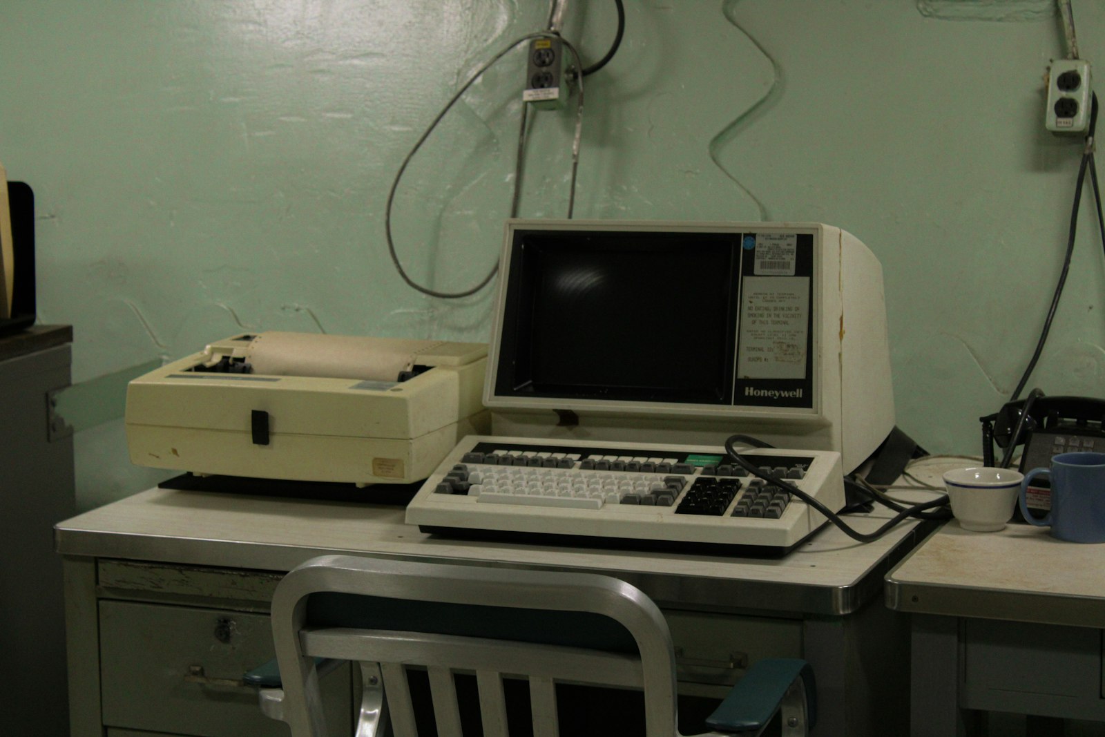 Computador pessoal vintage com monitor e impressora matricial sobre uma mesa de escritório