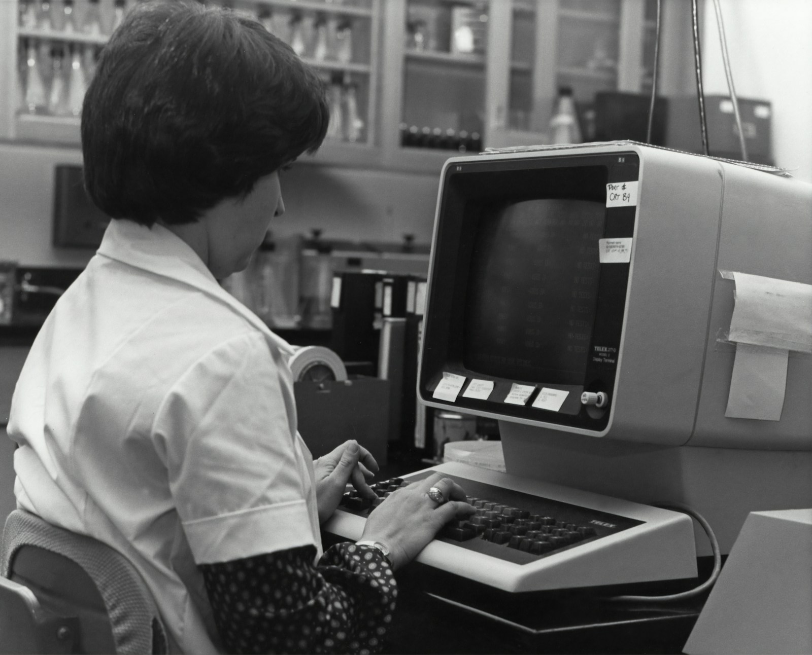 Fotografia histórica de uma funcionária inserindo dados em um terminal de computador nos anos 1980