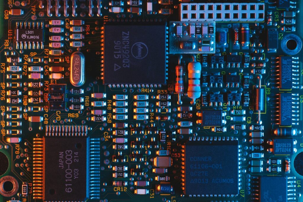 Chip de circuito integrado fotografado de perto, mostrando os pinos metálicos sobre a placa
